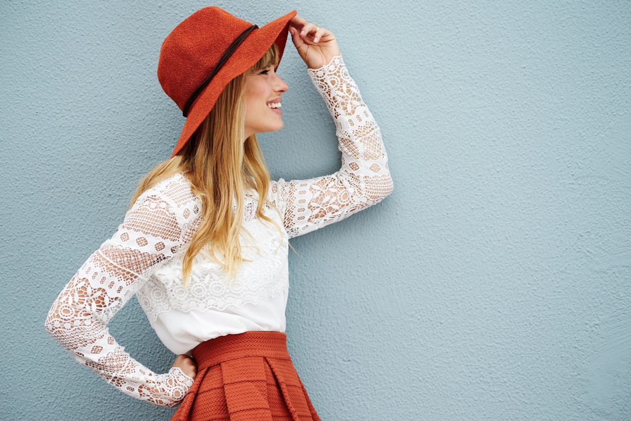 A woman in a red hat and white shirt.