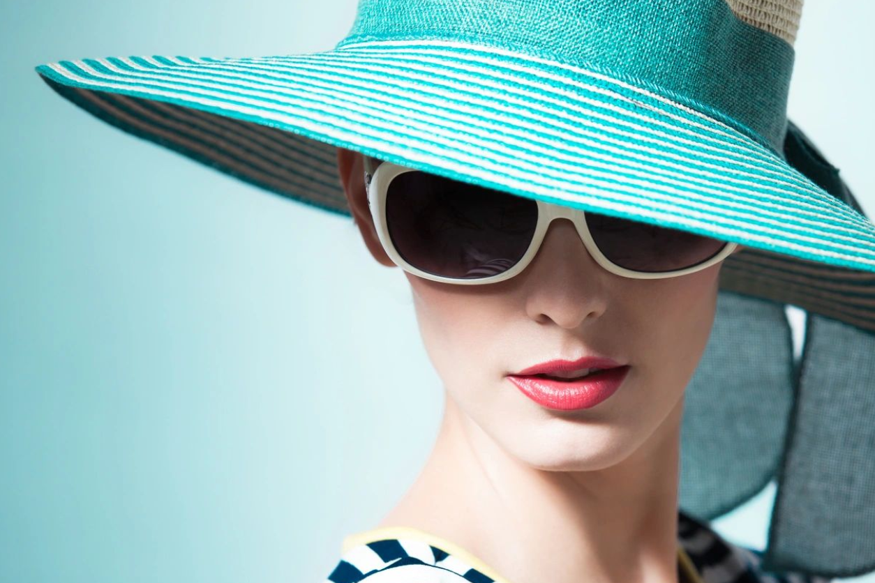 A woman wearing sunglasses and a hat.