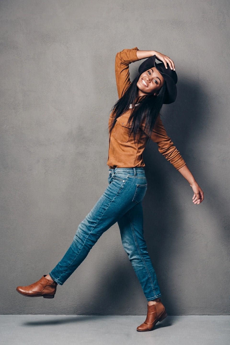 A woman in jeans and boots is dancing